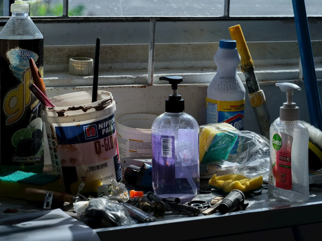 An adult man cleaning a glass window indoors, with attention to household chores and cleanliness.